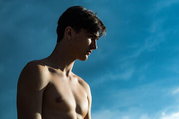 Young handsome sportsman with an ideal body, in front of the camera, abdominal muscles. Confident...