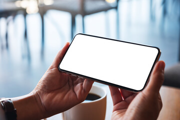 Mockup image of a woman holding mobile phone with blank white desktop screen