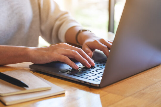 Closeup image of a woman working and typing on laptop computer in office