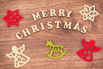 Inscription Merry Christmas with colorful decorations on rustic board