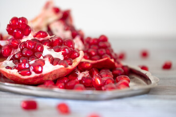 Bright and juicy pomegranate on a wooden table close-up