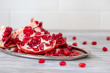 Bright and juicy pomegranate on a wooden table close-up