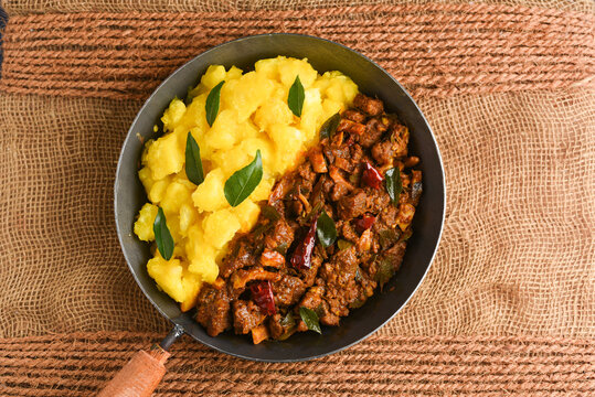 Cooked tapioca and spicy meat curry , Cassava root , Mandioca or Aipim,  Kerala special Kappa Puzhukku or Kappa biryani South Indian food  beef tapioca, India. with Fish curry. root vegetable Brazil