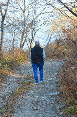 Fototapeta premium Young active athletic man walking in the forest, the concept of a healthy lifestyle, freedom and serenity, privacy with nature and a pleasant pastime for health