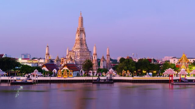 night to day time lapse of Wat Arun Temple with Chao Phraya river in Bangkok, Thailand