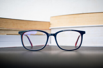 Eyeglasses and books on the table in a library