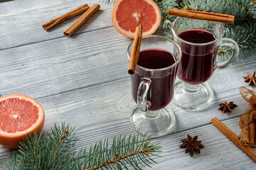 Obraz na płótnie Canvas Glasses with mulled wine on the table with spruce branches, grapefruit, cinnamon and star anise.