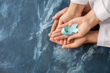 Hands of doctors with awareness ribbon on color background. Diabetes concept