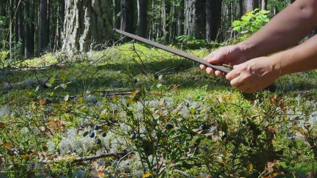 A Man Finds Rifle Weapon Dagger Blade In The Forest Moss.