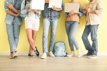 Students with modern devices near color wall