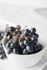 Bowl with sweet ripe grapes on table