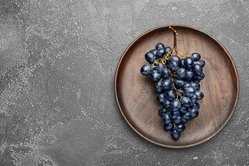 Plate with sweet ripe grapes on table