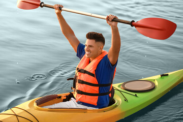 Young man kayaking in river