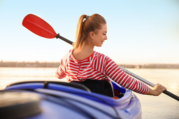 Young woman kayaking in river