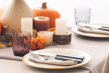 Beautiful table setting with pumpkins in dining room