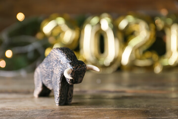 Figurine of bull as symbol of year 2021 on wooden table