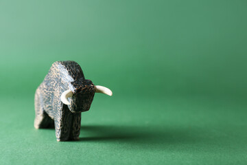 Figurine of bull as symbol of year 2021 on color background