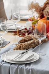 Beautiful table setting with pumpkins in dining room