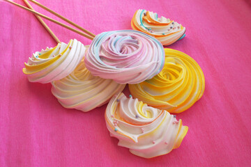Colored meringues on a pink background. New Year's sweets.