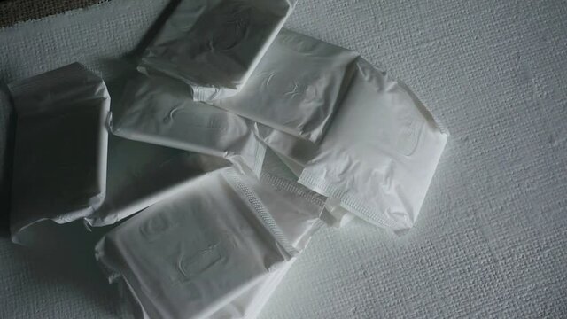 A pile of maxi pads on a white surface piled high Menstrual protection sanitary