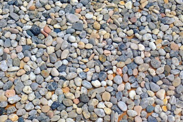 River rock pebble stones under clear water in the pool.