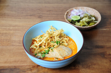 Khao Soi Kai, Thai spicy food in white blow on wooden table, Thai spicy soup. Thai Food.