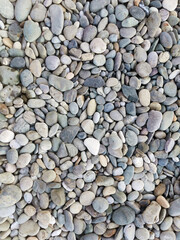 Multicolored smooth stones by the sea, top view. Abstract background.