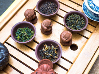 Assortment of Chinese tea, clay mugs on wooden table