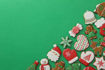 Different Christmas gingerbread cookies on green background, flat lay. Space for text
