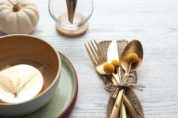 Autumn table setting and pumpkin on white wooden background, closeup