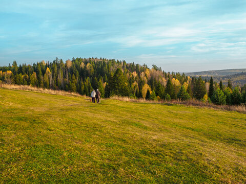 An elderly couple walks in a Stone Hill nature park in autumn day.