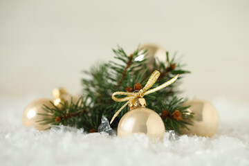 Fototapeta na wymiar Beautiful Christmas balls and fir branch on snow against white background