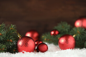 Beautiful Christmas balls and fir branches on snow. Space for text