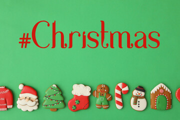 Hashtag Christmas and different gingerbread cookies on green background, flat lay