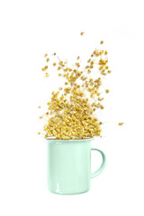 top view of a ceramic cup with dried chamomile flowers isolated on a white background.