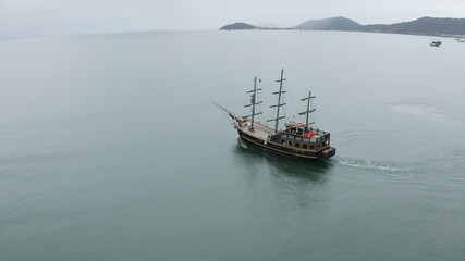 Tourist boat on the coast, aerial film from Florianópolis Santa Catarina Brazil