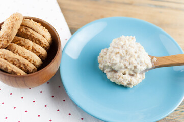 Breakfast: Healthy food classic porridge in blue dish on wood background. oatmeal food breakfast. Top view.