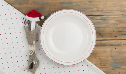 Top view of kitchen cutlery setting with polka dot napkin on grunge restaurant table. Christmas menu