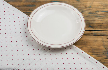 Top view of kitchen cutlery setting with polka dot napkin on grunge restaurant table.