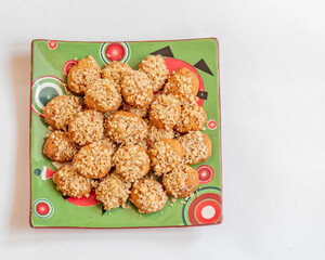 melomacarona plate, traditional Greek Christmas gourmet cookies with honey syrup and nuts on a white background