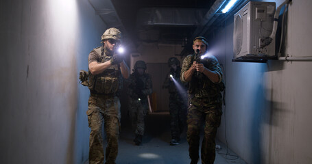 Soldiers with flashlights inspecting dark corridor