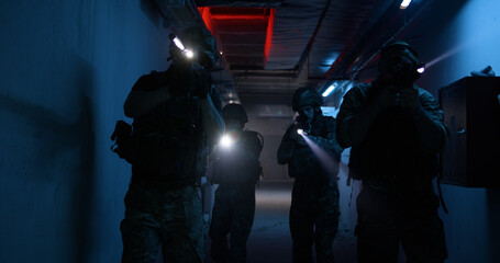 Soldiers with flashlights inspecting dark corridor