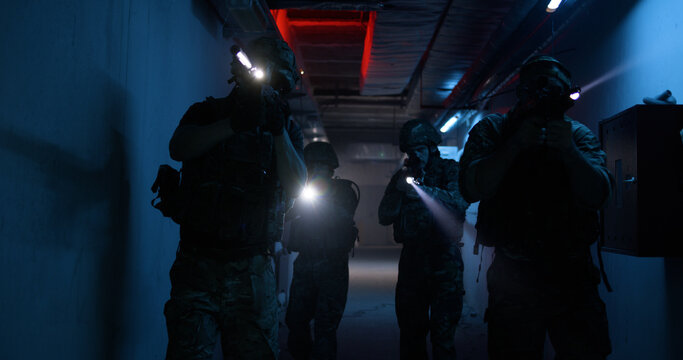 Soldiers with flashlights inspecting dark corridor