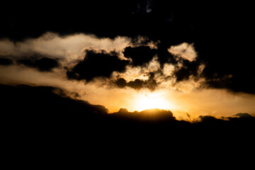 Thick dark clouds surround the sun, background of sky turn to be orange