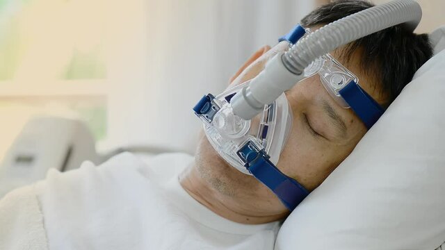 Obstructive sleep apnea therapy,hd video.
Healthy senior man wearing ventilator mask and adjusting to fit his face ,healthcare concept.