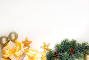 New Year's gifts with a golden bow, a fir branch on a light background. Flat lay, top view, copy space for text. Christmas festive composition.