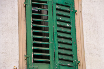 Behind the closed green window shutters