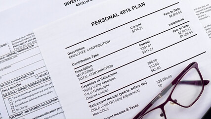 Pension savings. Glasses and pen are on the background Blank form Investment contract 401 k or 457...