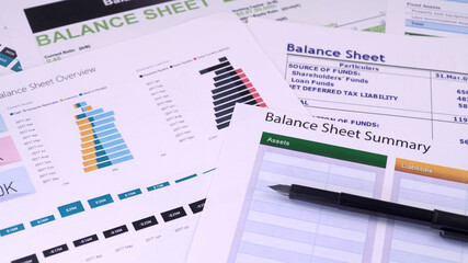 Conceptual composition. Balance sheet summary form and pen on the background of financial documents, close-up