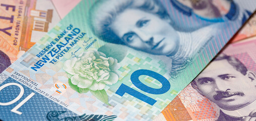 New Zealand Currency - New Zealand ten dollar banknote laid over a fifty dollar note. Close up in a...